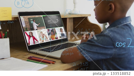 Watching boy following online math lesson at home desk with laptop pencils notebook, copy space Watching boy following online math lesson at home desk with laptop pencils notebook, copy space 133518852