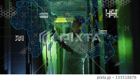 Reaching Korean engineer wearing lab coat holding tablet in green data center corridor, network map Reaching Korean engineer wearing lab coat holding tablet in green data center corridor, network map 133518876