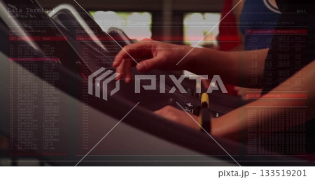 Gym-goer arms in workout shirt gripping rail and tapping touchscreen in gym, with safety key clip 133519201