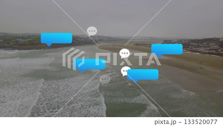 Floating blue and white chat bubbles hovering over coastal beach aerial view, with ocean waves foam Floating blue and white chat bubbles hovering over coastal beach aerial view, with ocean waves foam 133520077