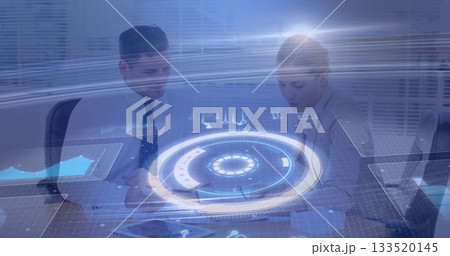 Colleagues in suits reviewing documents using holographic charts at conference table with tablet 133520145