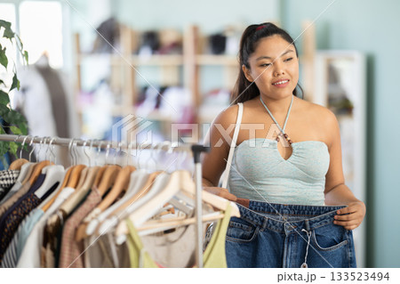 Young woman choosing jeans in clothing store 133523494