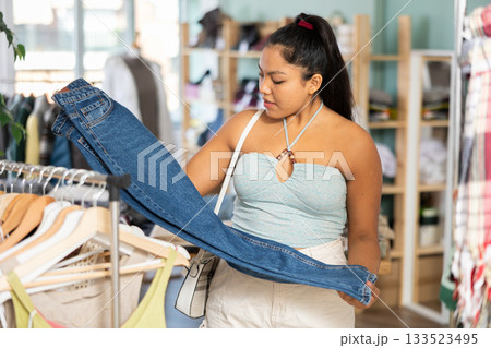 Girl at trading floor pick out and buying jeans trousers 133523495