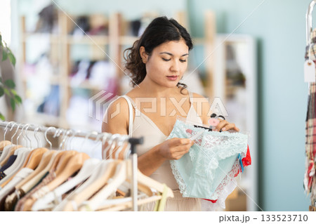 Female shopper selects panties in fashionable clothing boutique 133523710