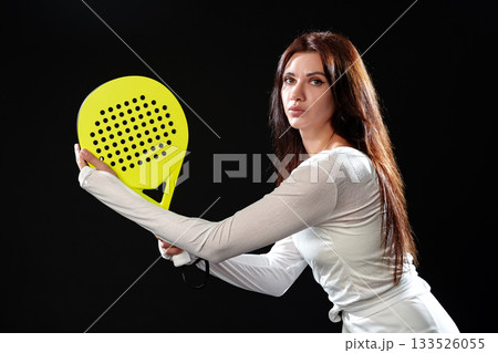 Player prepares for a shot in a padel match with a bright yellow paddle in hand Player prepares for a shot in a padel match with a bright yellow paddle in hand 133526055
