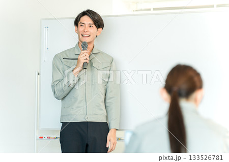 工場・会議室で講習・セミナー・勉強会・プレゼンをする作業服を着たエンジニア・講師・技術者の男性 工場・会議室で講習・セミナー・勉強会・プレゼンをする作業服を着たエンジニア・講師・技術者の男性 133526781