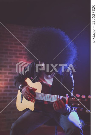Man playing guitar in nightclub during concert Man playing guitar in nightclub during concert 133527820