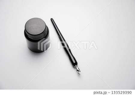 fountain pen with a bottle of ink on a white table. Stylish fountain pen on a white background. Stationery. Poetic ideas 133529390