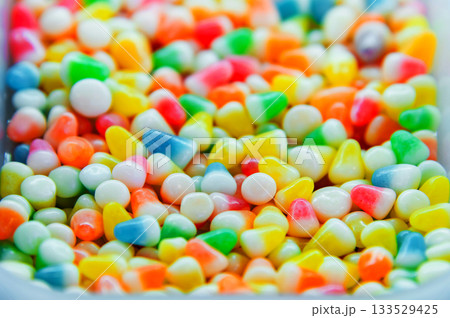 Colorful background of multicolored, shiny, round, chewy candies. A background photo of colorful sweets. A close-up photo of the candies taken in a candy store 133529425