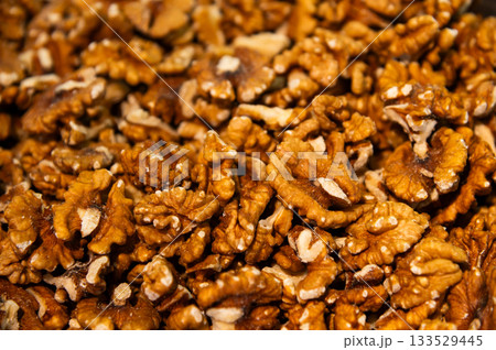 Raw, shelled walnuts, many nuts in the background. Bright brown, broken walnuts, freshly harvested 133529445