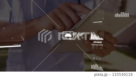 Tapping man in hoodie using touchscreen tablet on sunlit patio with floating data overlays Tapping man in hoodie using touchscreen tablet on sunlit patio with floating data overlays 133530119