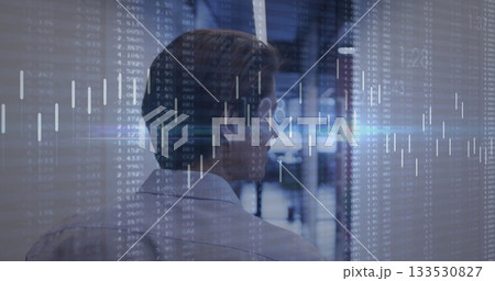 Reviewing chart overlays, man in collared shirt studying data in office, with monitors, copy space 133530827