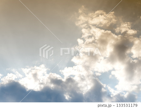 Clouds in dramatic sky with sunlight. Bright atmosphere with golden and blue tones, fluffy 133531179