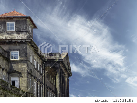 Building facade with columns and tiled roof. Classical architecture in European city with heritage Building facade with columns and tiled roof. Classical architecture in European city with heritage 133531195