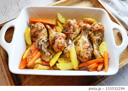 Roasted chicken legs with vegetables in white pan 133532294