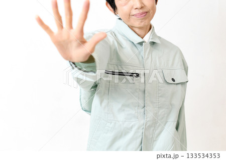 作業服姿の女性が手でストップポーズをする 133534353