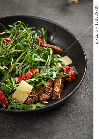 Fresh arugula salad with beef and sundried tomatoes Fresh arugula salad with beef and sundried tomatoes 133535787