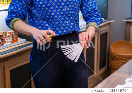 Perfume tasting. Perfume is applied to paper sticks. Hands hold a bottle and spray Perfume tasting. Perfume is applied to paper sticks. Hands hold a bottle and spray 133536704