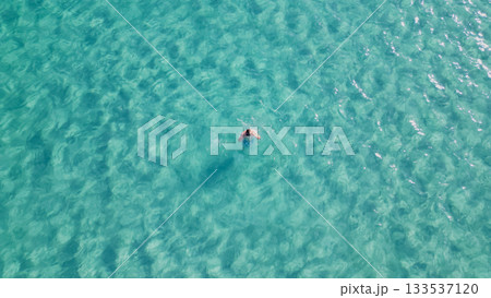 Young man swimming with mask in crystal clear turquoise sea water. 133537120