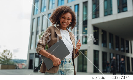 female professional happily engaging outdoors, enthusiastic woman with laptop in urban environment female professional happily engaging outdoors, enthusiastic woman with laptop in urban environment 133537374