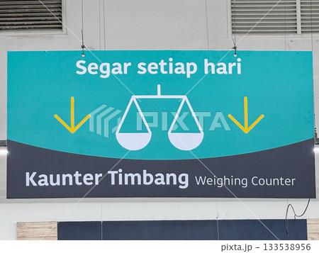 Weighing counter sign with scales and fresh produce message at grocery shop 133538956