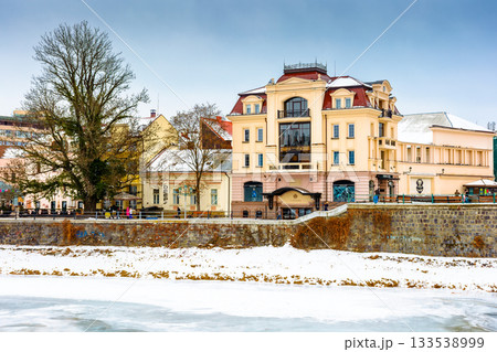 uzhhorod, ukraine - 09 jan 2017: christmas time in the old town in winter. snow covered embankment of ice frozen river uzh. cold weather. timeless photo of transcarpathia capital on holiday season uzhhorod, ukraine - 09 jan 2017: christmas time in the old town in winter. snow covered embankment of ice frozen river uzh. cold weather. timeless photo of transcarpathia capital on holiday season 133538999