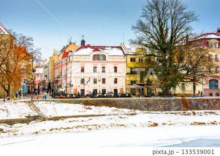 uzhhorod, ukraine - 09 jan 2017: christmas time in the old town in winter. snow covered embankment of ice frozen river uzh. cold weather. timeless photo of transcarpathia capital on holiday season 133539001