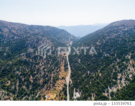 Long mountain road along forest in Crete, aerial drone photo. Long mountain road along forest in Crete, aerial drone photo. 133539761