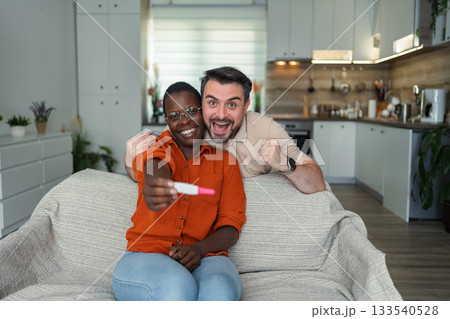 Excited multi-ethnic couple sharing pregnancy test result at home Excited multi-ethnic couple sharing pregnancy test result at home 133540528