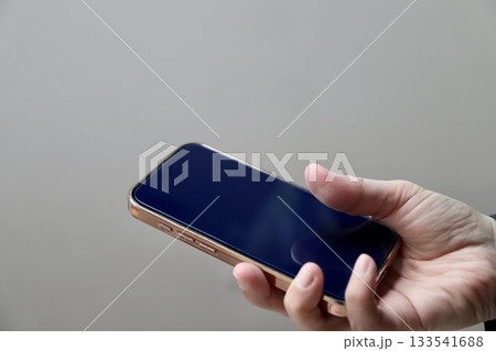 中年女性が右手に持ったスマートフォン 中年女性が右手に持ったスマートフォン 133541688