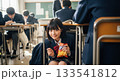 隠れてお菓子を食べる女子高生 133541812