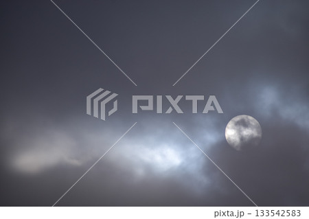Full moon with dramatic cloudscape. Cloudy overcast sky with moon. Nature scene. 133542583