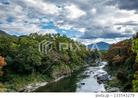 長瀞渓谷の荒川、紅葉が始まった山とドラマチックな秋の空 133543279