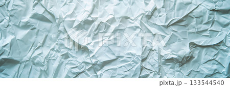 A crumpled light blue paper offers a detailed textured background with shadows and highlights. A crumpled light blue paper offers a detailed textured background with shadows and highlights. 133544540