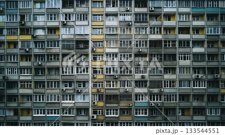 The geometric pattern facade of a densely packed apartment building creates a monotonous urban texture. 133544551
