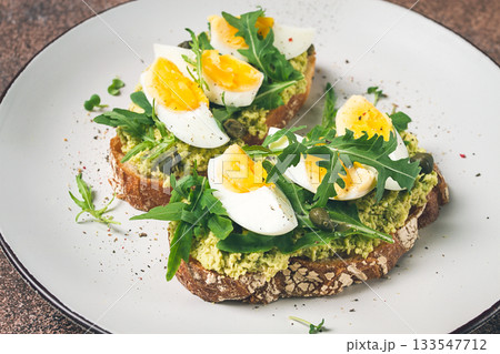 sandwich with mashed avocado, boiled egg, and arugula, on bread , homemade, breakfast, 133547712