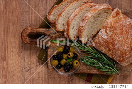 sliced ciabatta , on a chopping board, with rosemary and olives, Italian bread, close-up, Italian cuisine, breakfast, no people, sliced ciabatta , on a chopping board, with rosemary and olives, Italian bread, close-up, Italian cuisine, breakfast, no people, 133547714