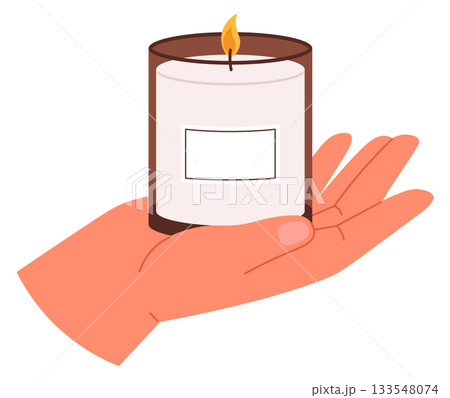 A hand holding a candle in a glass container 133548074