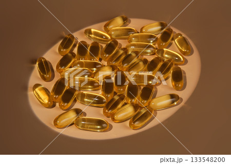 Golden omega 3 fish oil capsules on beige background 133548200