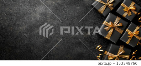 Three elegantly wrapped black gifts with orange bows sit neatly on a dark surface, perfect for any festive celebration 133548760