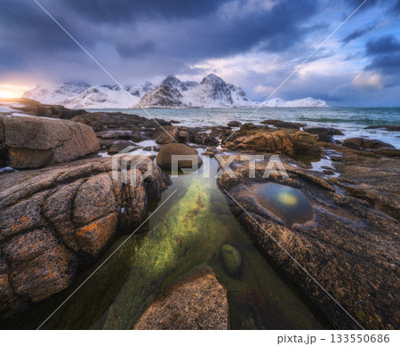 Rock pools and snowy mountains on the Lofoten coast, Norway Rock pools and snowy mountains on the Lofoten coast, Norway 133550686