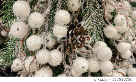 Christmas background with frosted pine needles white glittering berries and a natural pine cone decor 133550756