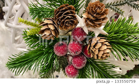 Christmas holiday arrangement of pinecones frosted red berries and green pine needles on a white background 133550759