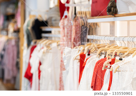 Women's clothes hanging on rack in store 133550901