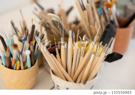 Pottery tools for processing handmade clay work pieces on the table 133550983