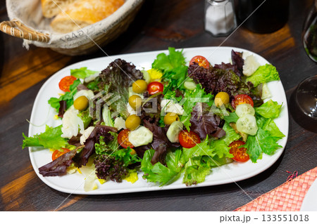 Crisp salad with lettuce, tomatoes, cucumbers, cauliflower, and olives Crisp salad with lettuce, tomatoes, cucumbers, cauliflower, and olives 133551018