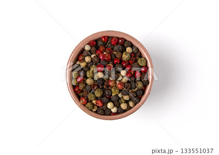 Mixed multicolored peppercorns in a ceramic bowl isolated on white background Mixed multicolored peppercorns in a ceramic bowl isolated on white background 133551037