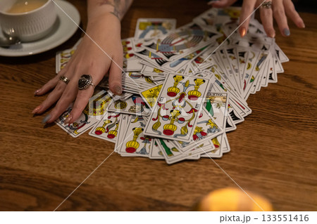 Tarot cards and fortune telling. Soothsayer predicting future with tarot cards. Unrecognizable mysterious fortuneteller holding tarot cards forecasting future for client. Future reading esoteric 133551416