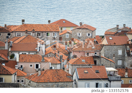 A scenic view of a coastal old town packed with terracotta tiled roofs. Budva A scenic view of a coastal old town packed with terracotta tiled roofs. Budva 133552576