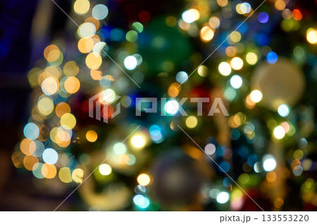 Soft, defocused lights form bright circles in a festive abstract scene. The multicolor bokeh creates a dreamy holiday background. 133553220